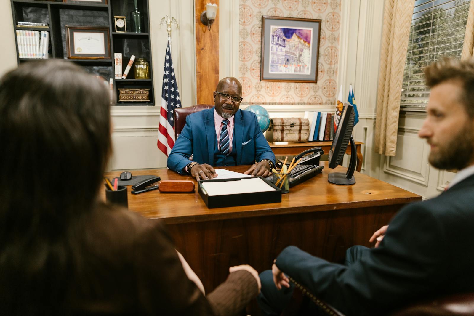 Family law attorney sitting across from a couple during an initial divorce consultation in a wood-paneled office