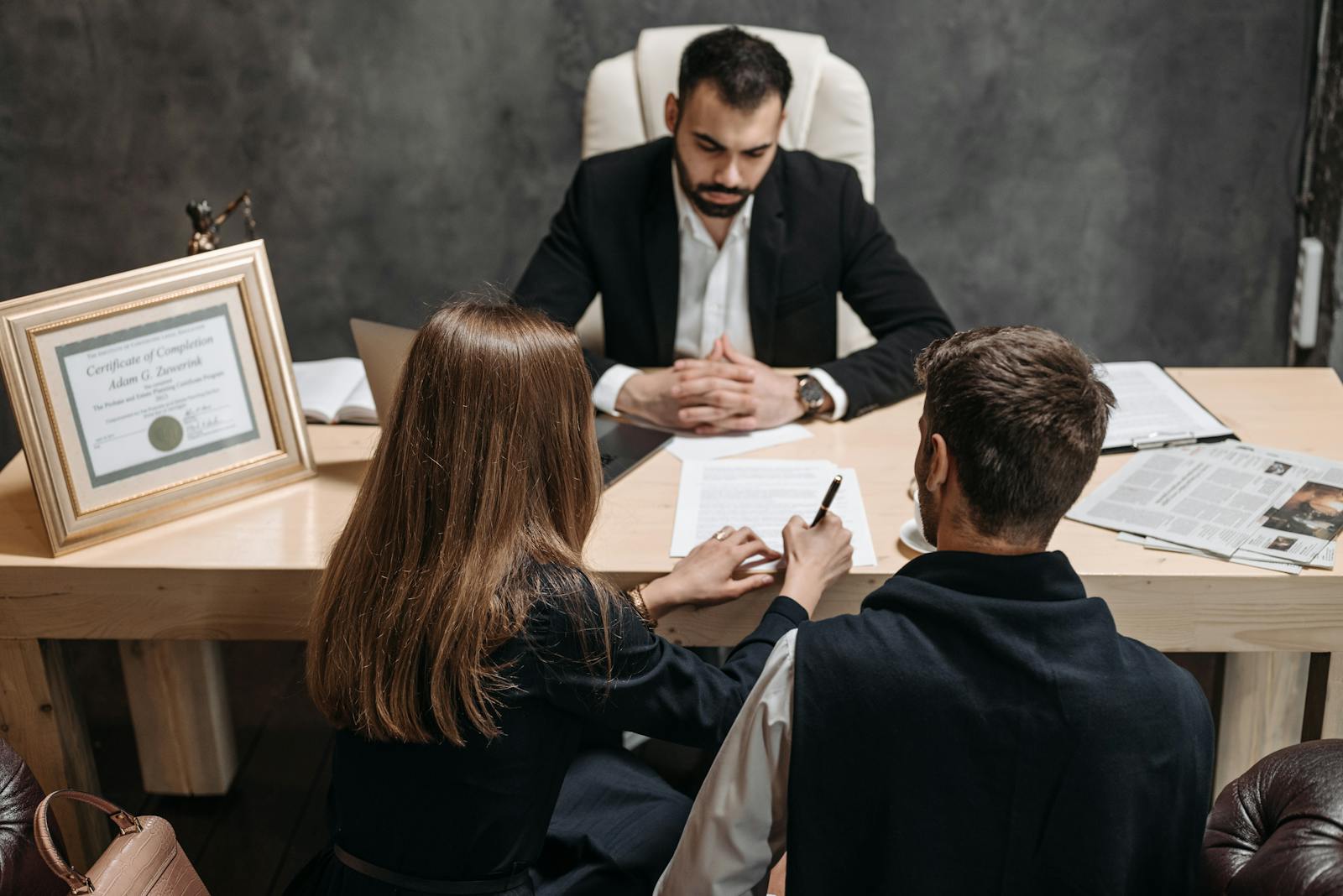 Family law attorney meeting with a couple to review and sign legal documents