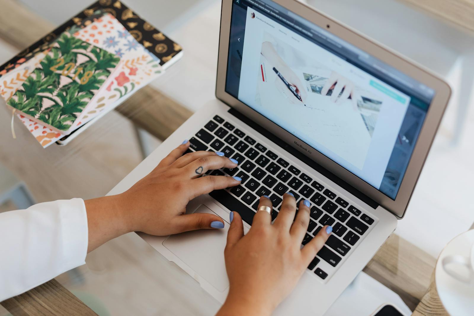 Hands typing on a laptop drafting a blog post in a content management system
