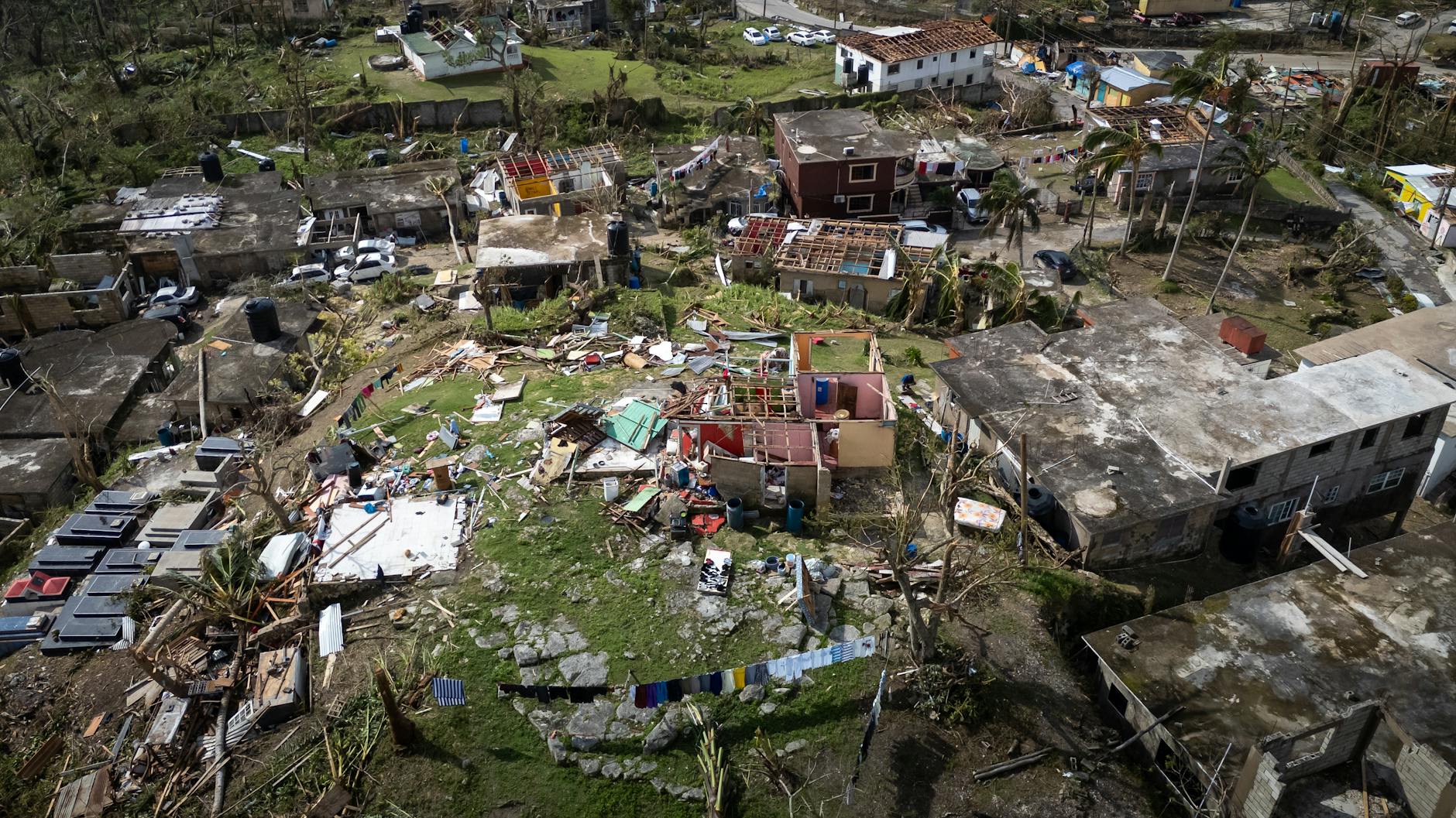 Aerial view of neighborhood storm damage with destroyed rooftops