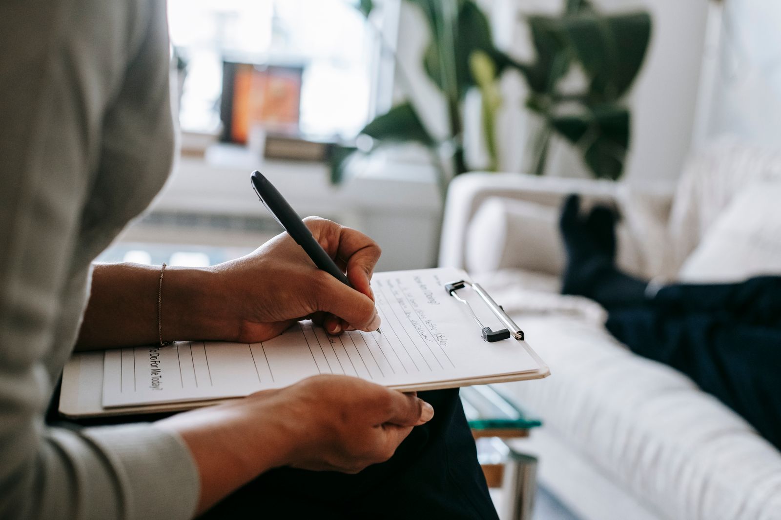Therapist holding a clipboard with an intake form during a new client session