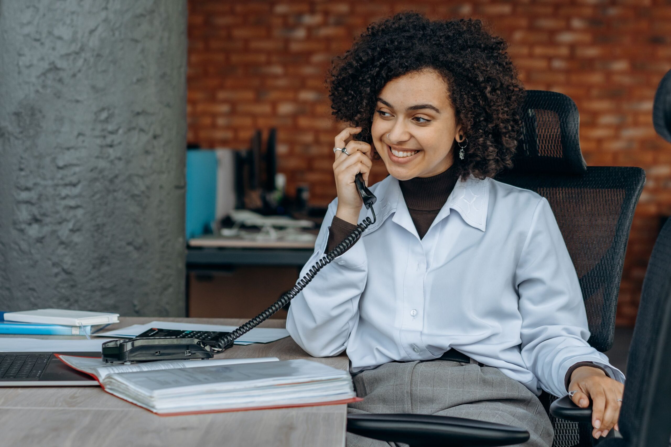 Business owner smiling while answering an inbound call from an SEO-generated lead