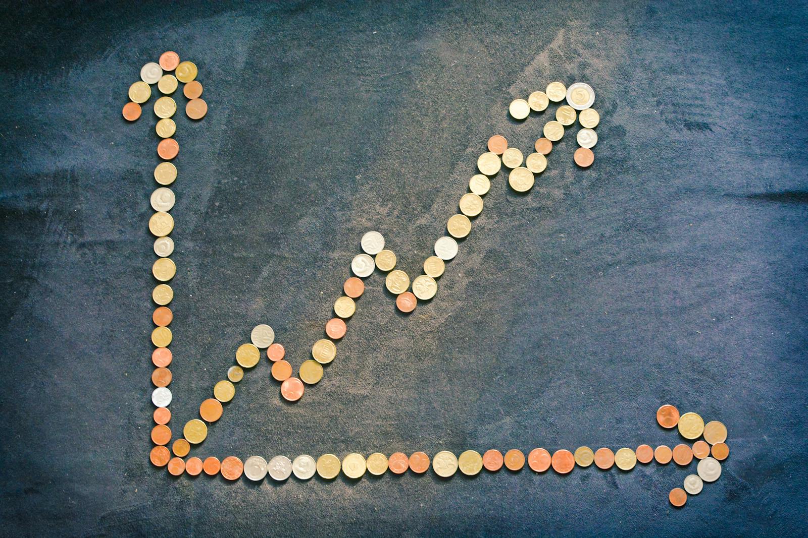 Upward-trending growth chart made of coins on a dark surface, illustrating compounding SEO returns