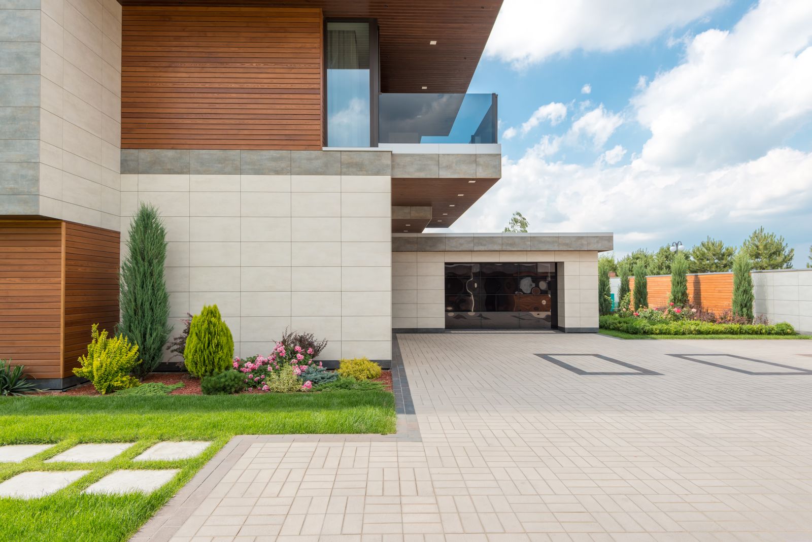 Modern residential home with a wide concrete driveway and landscaped front yard