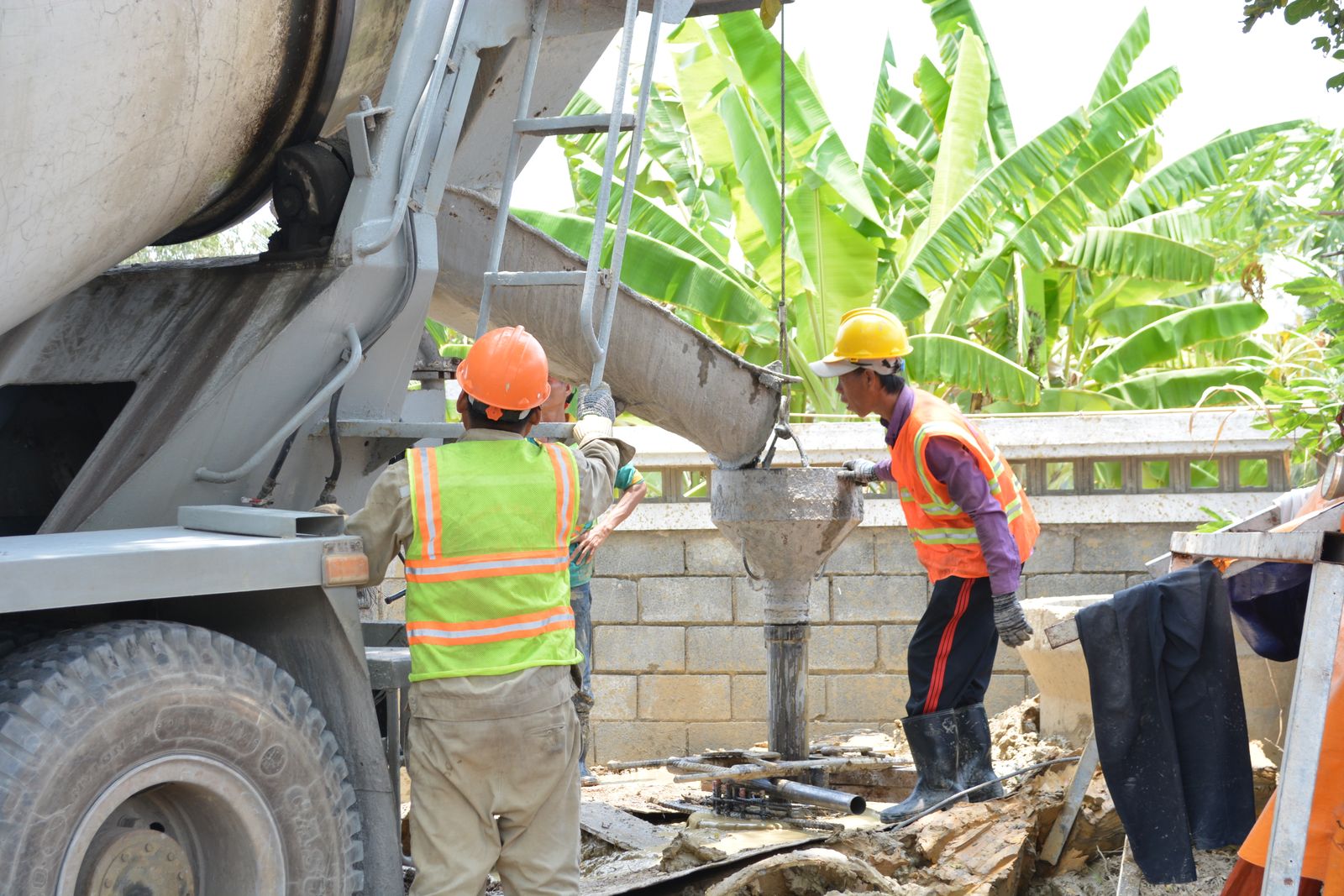 Concrete crew pouring slab from a mixer truck on a residential job site