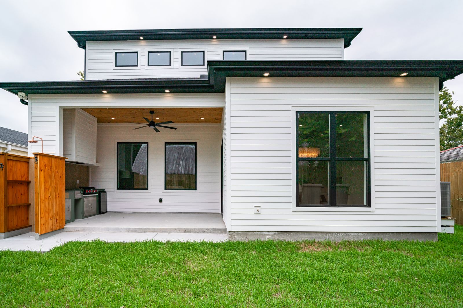Residential backyard with a newly finished concrete patio and covered porch