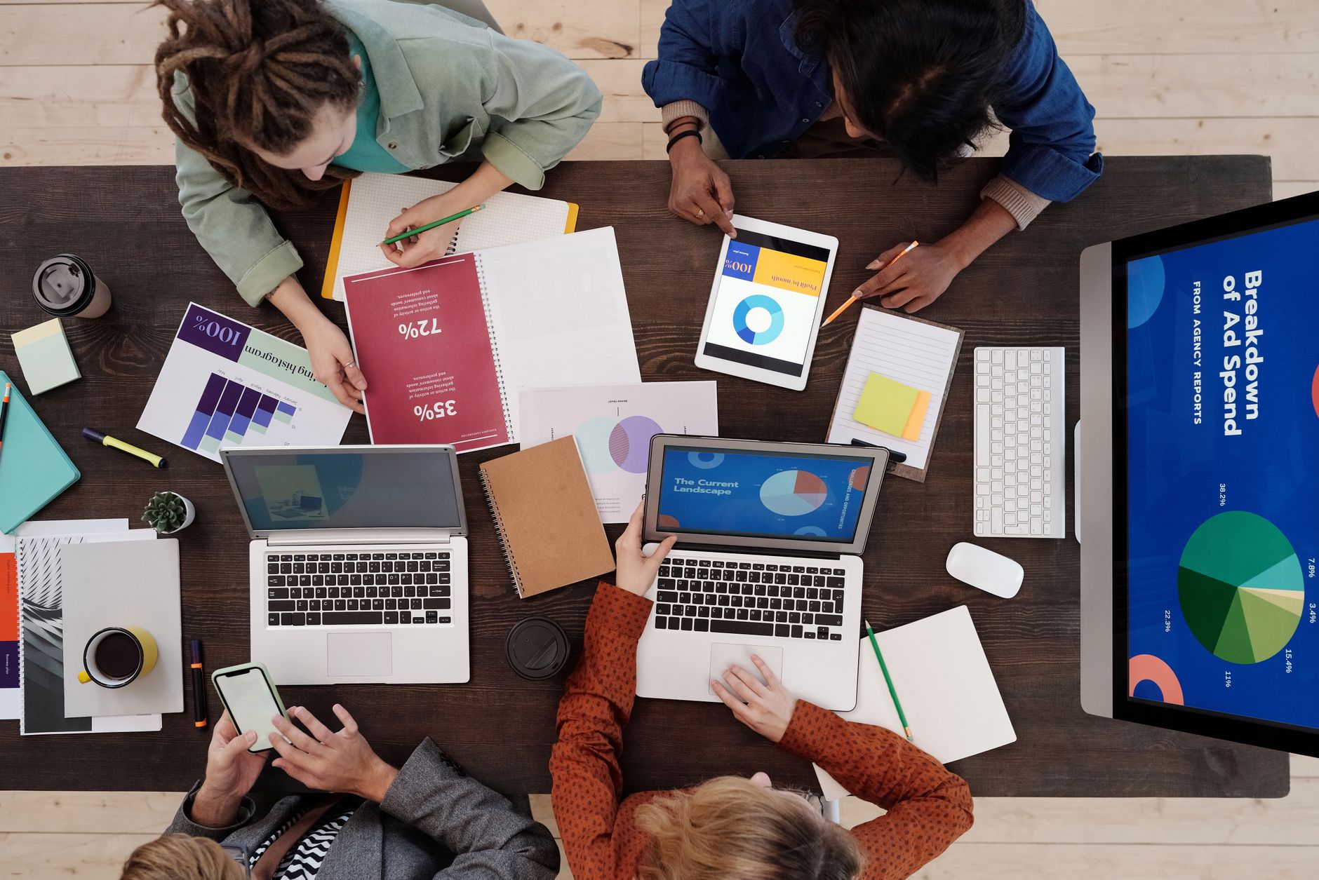 Marketing team reviewing content strategy and ad spend reports around a table
