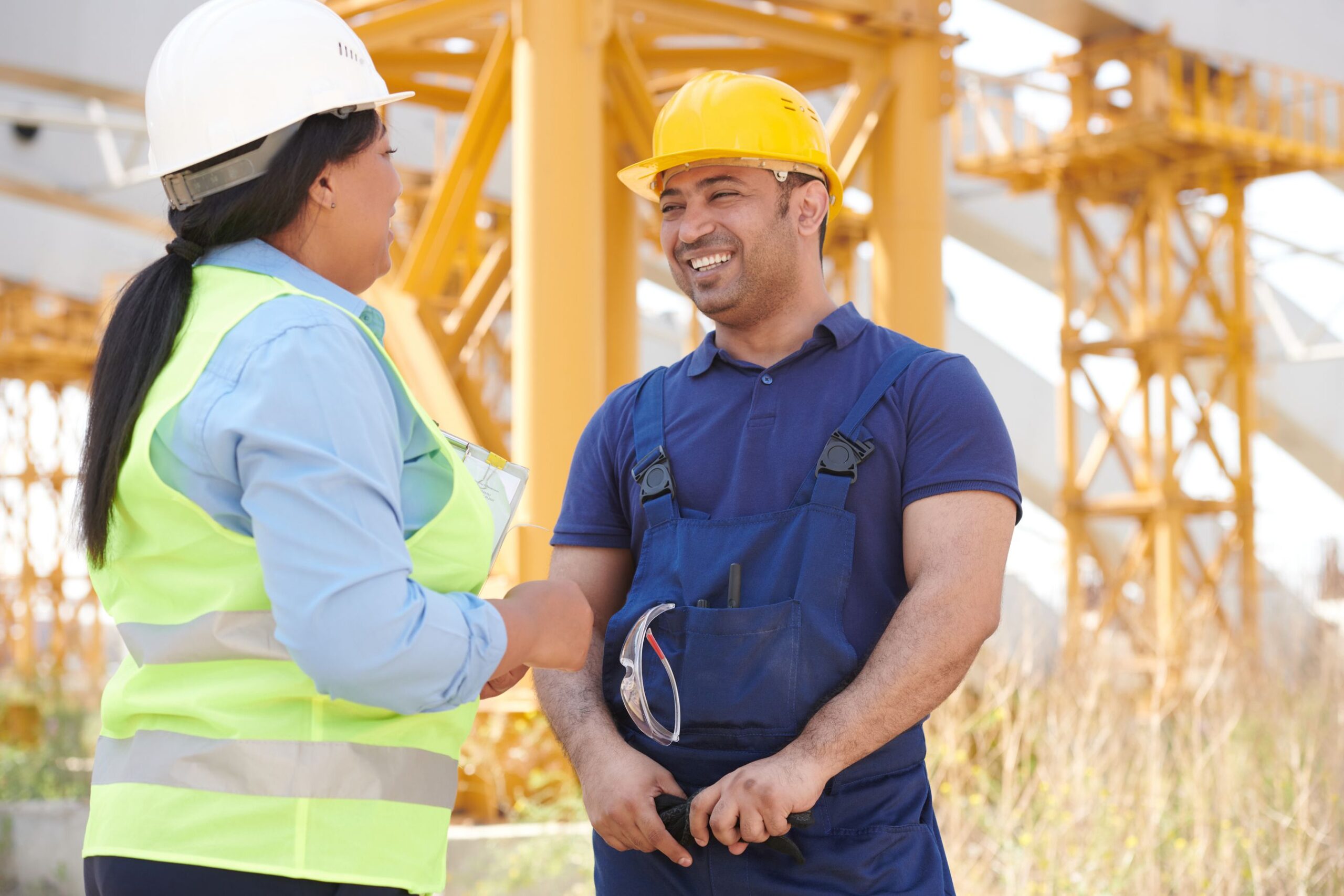 Two contractors shaking hands at a construction site after securing a long-term client through organic search
