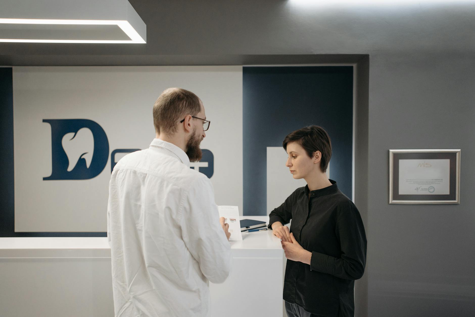 Cosmetic dentist consulting a patient about veneer options in a modern dental clinic