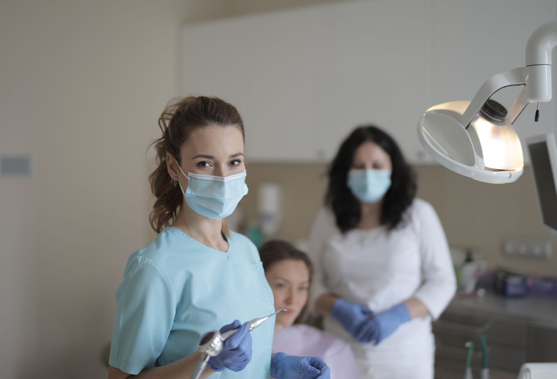 Dental team in face masks working in a treatment room