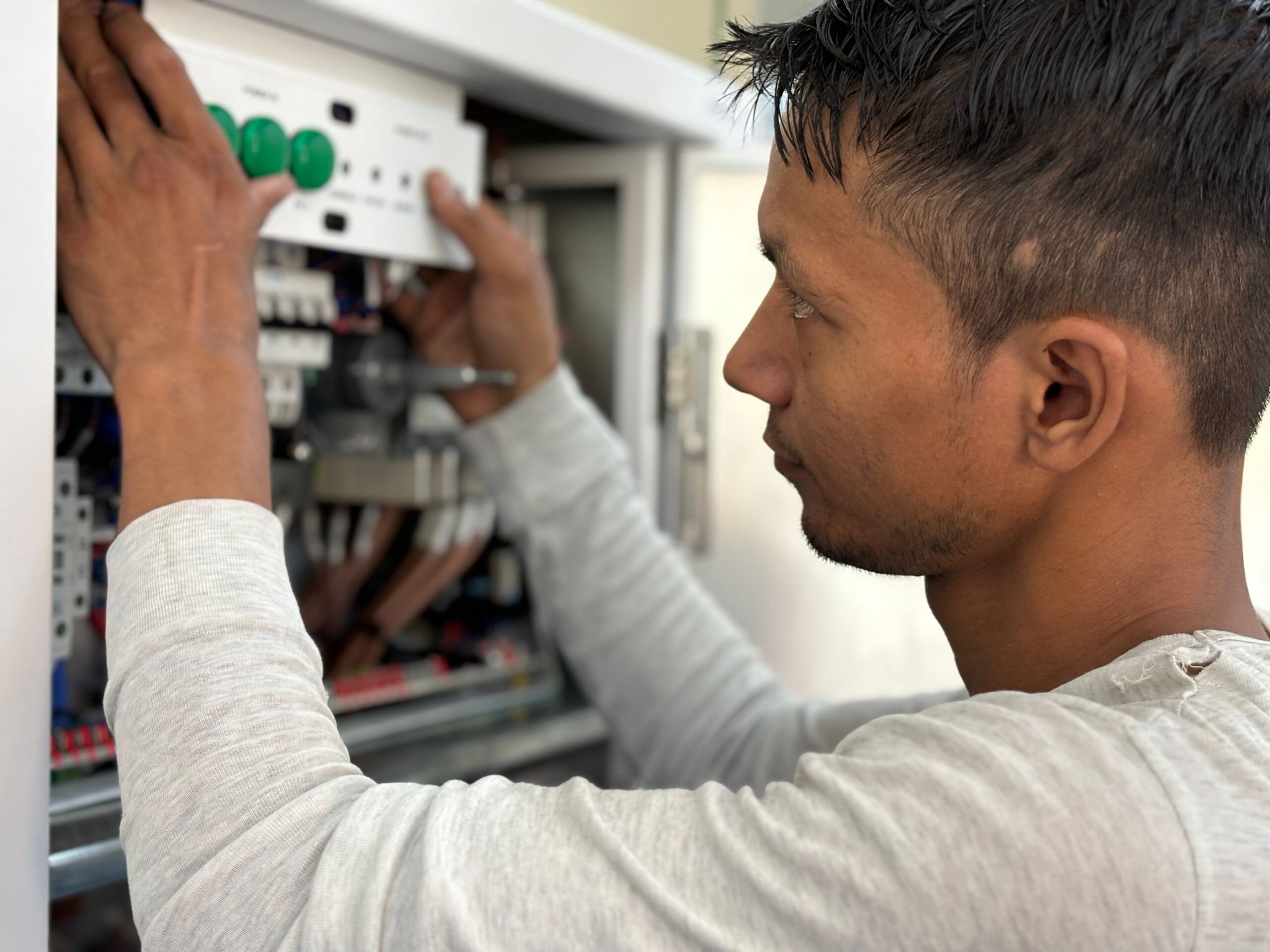 Residential electrician adjusting a circuit breaker panel during a service call