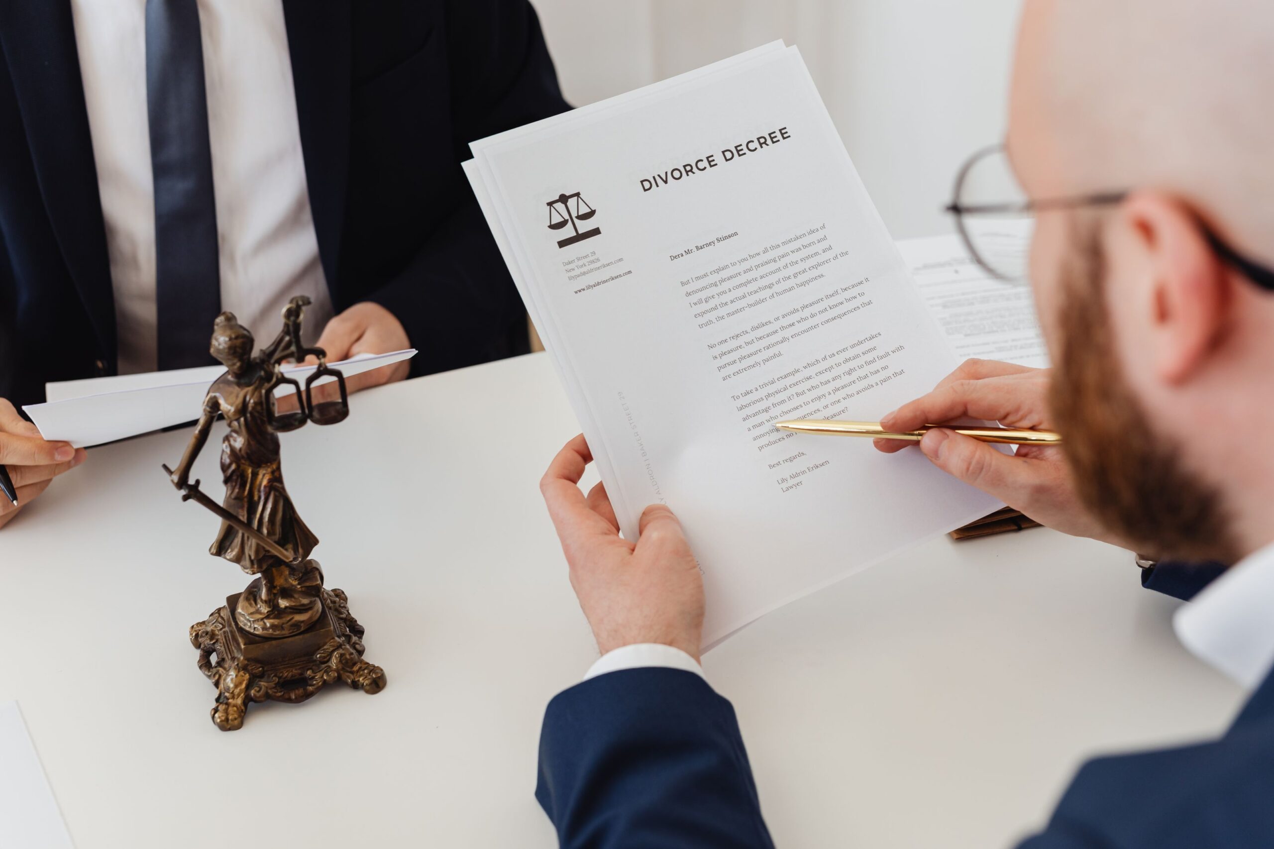 An attorney reviewing a divorce decree document with a client at a desk