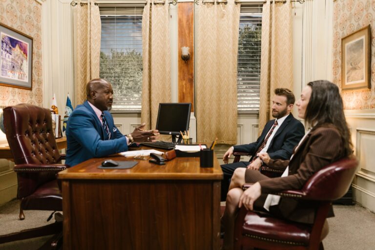 Family law attorney consulting with a married couple across a desk in a private office