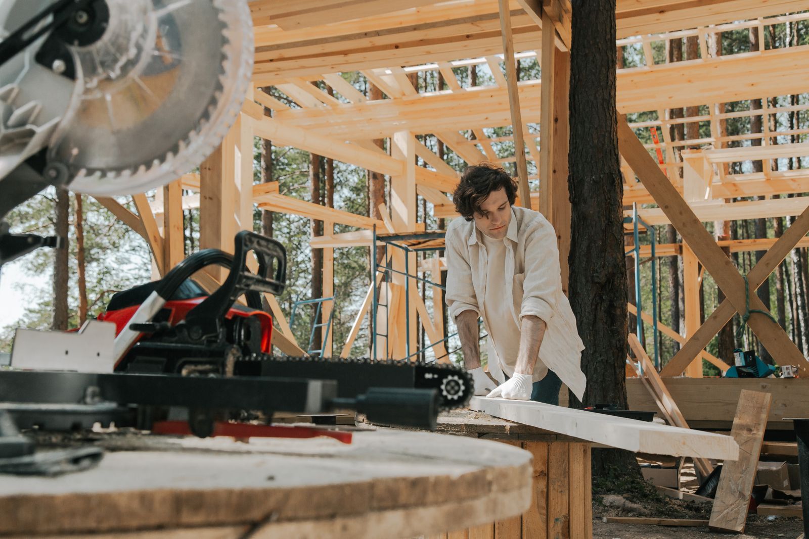 Carpenter measuring and cutting wood lumber on a job site