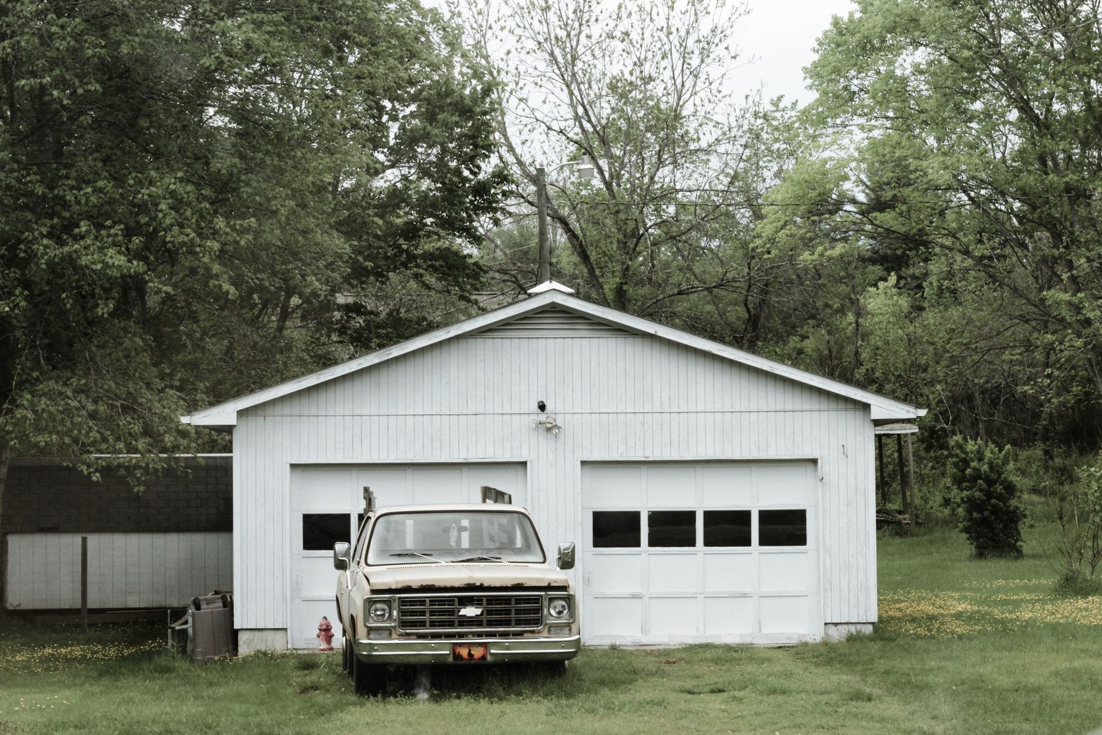 Detached residential garage with white panel doors in a quiet neighborhood