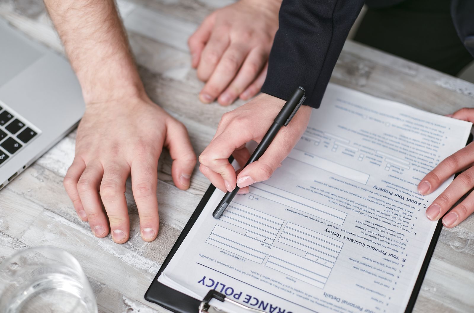 Insurance broker and client reviewing a policy document at a desk