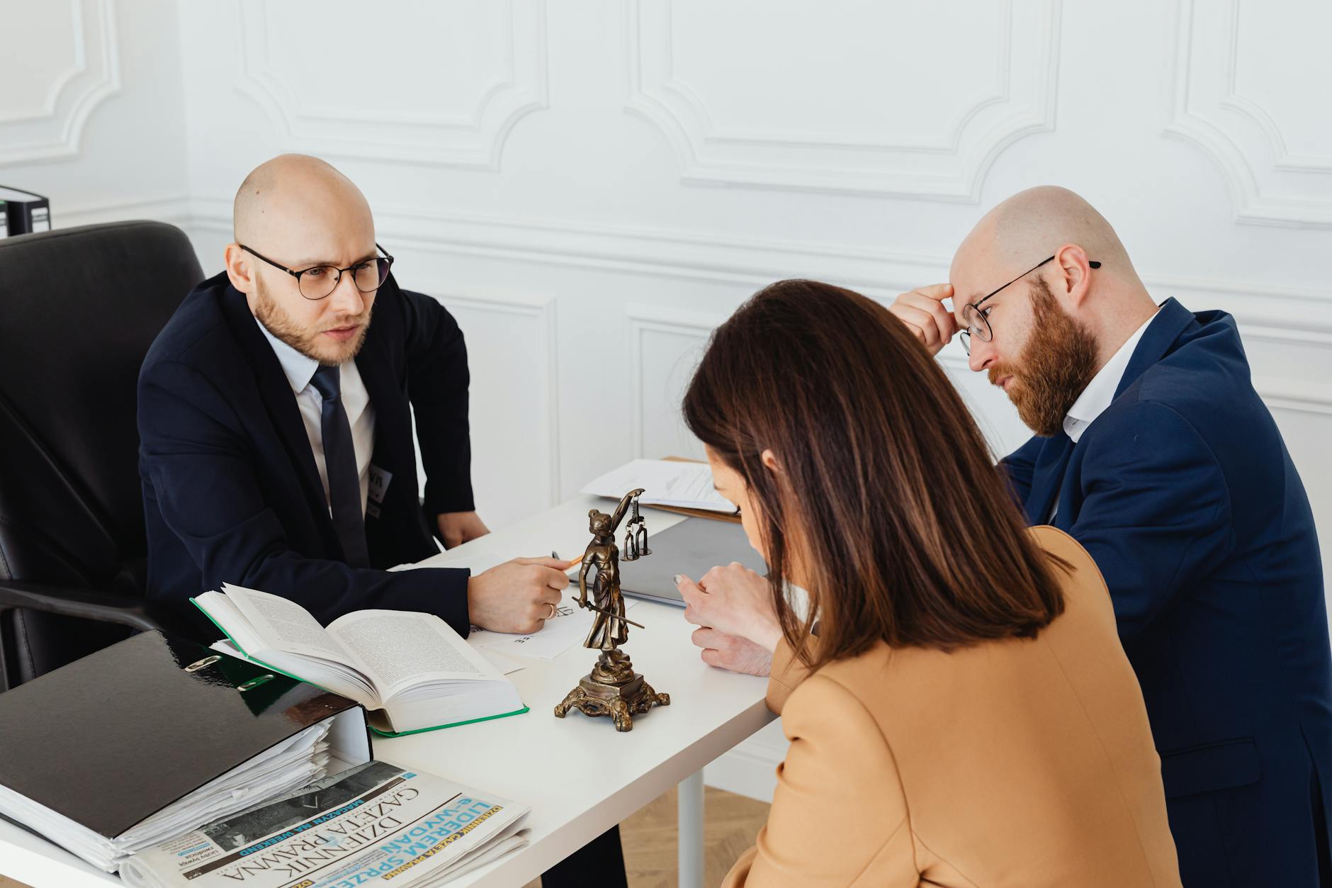 Immigration attorney sitting across the desk from a couple during a serious legal consultation
