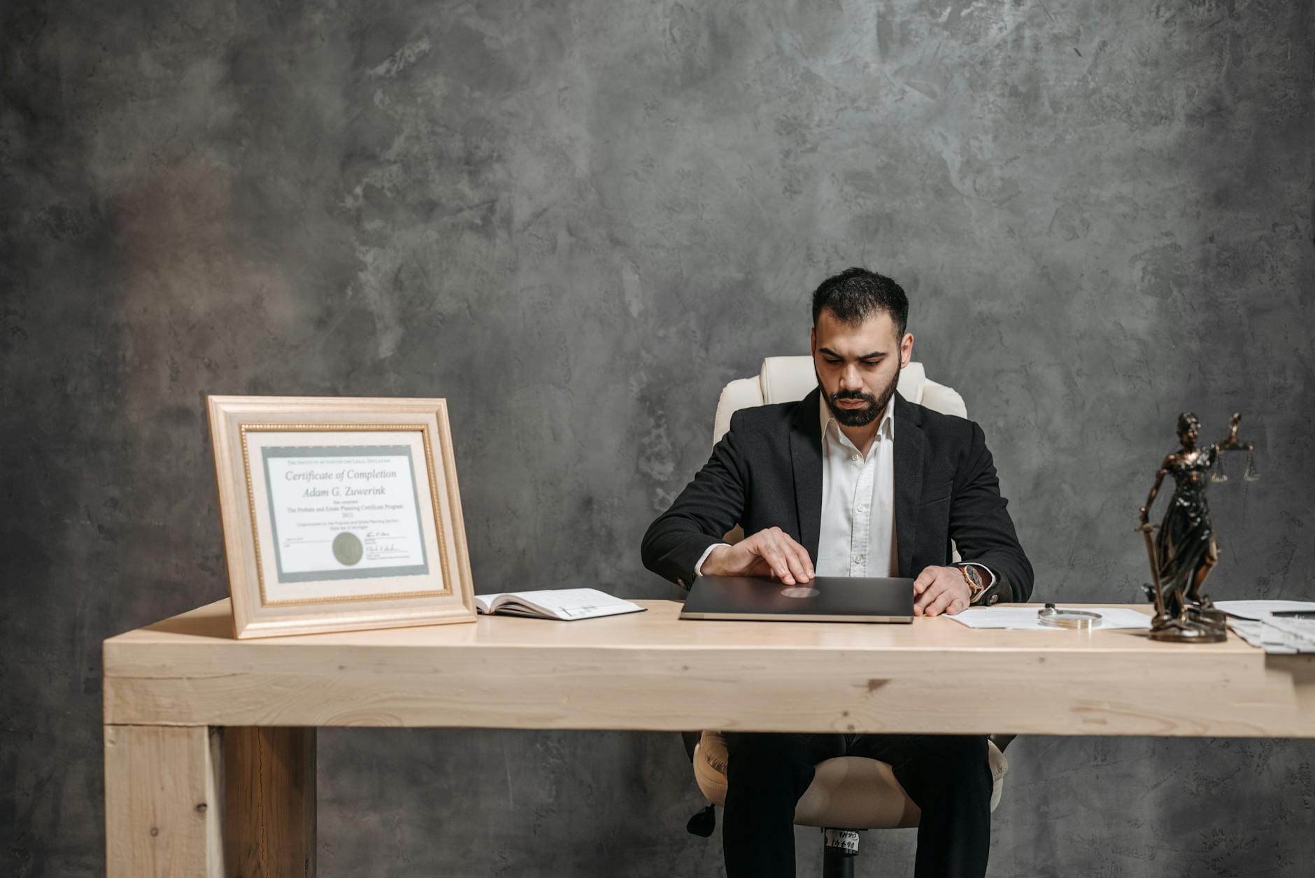 Immigration attorney working at his desk with certifications and legal documents visible
