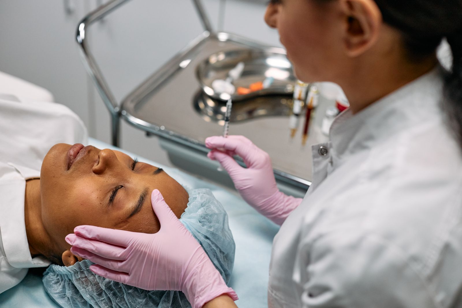 Dermatology professional administering injectable cosmetic treatment in a clinical setting