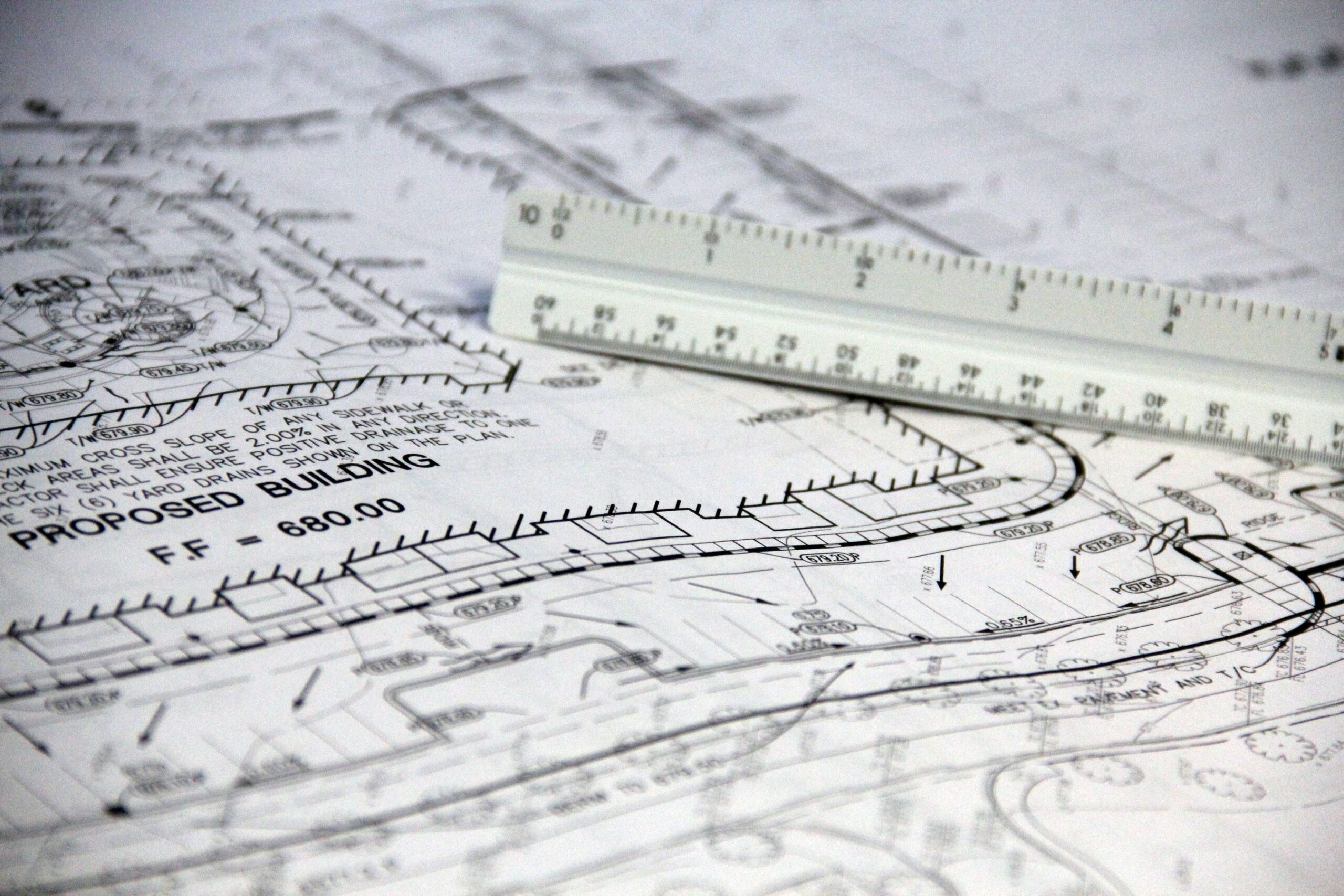 Architectural blueprint of a proposed building with a scale ruler used during project estimating