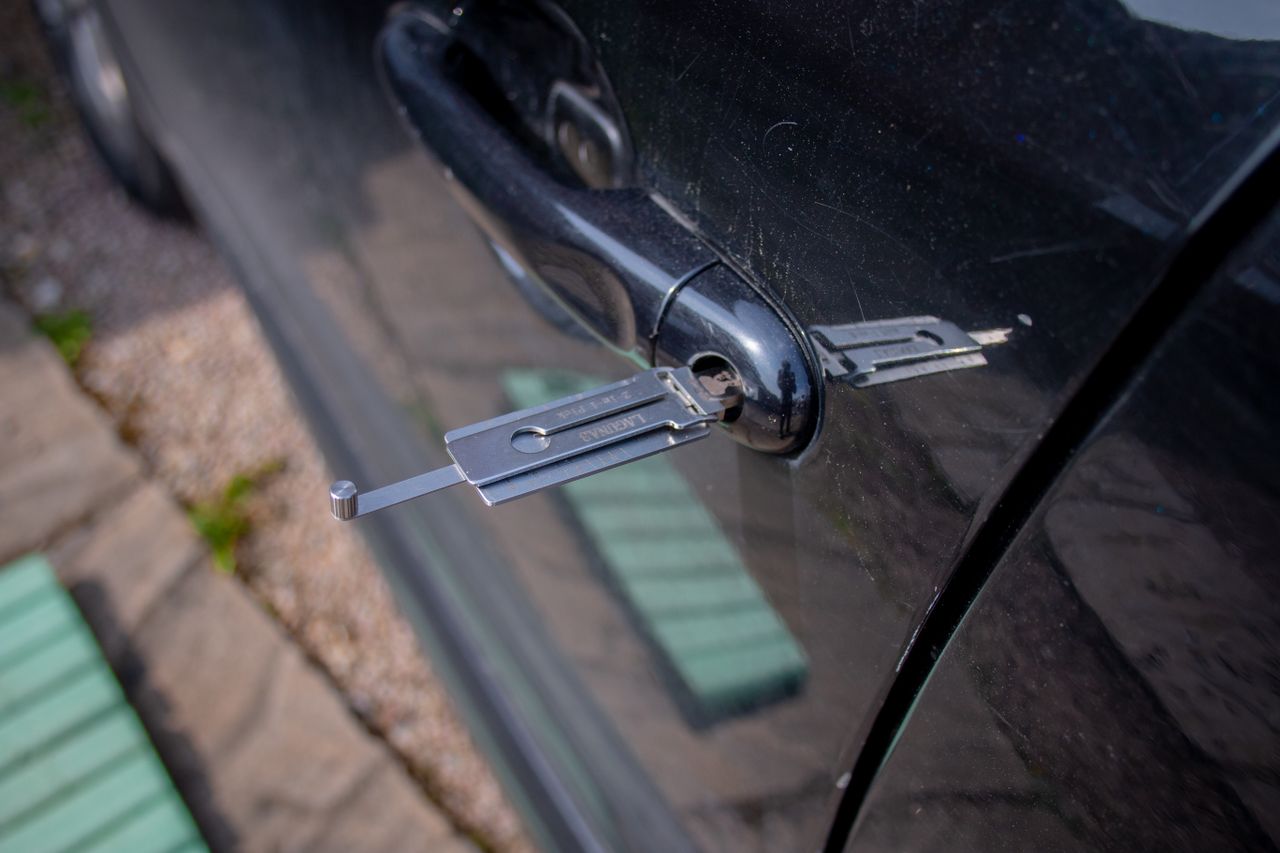 Close-up of a locksmith tool being used to unlock a car door