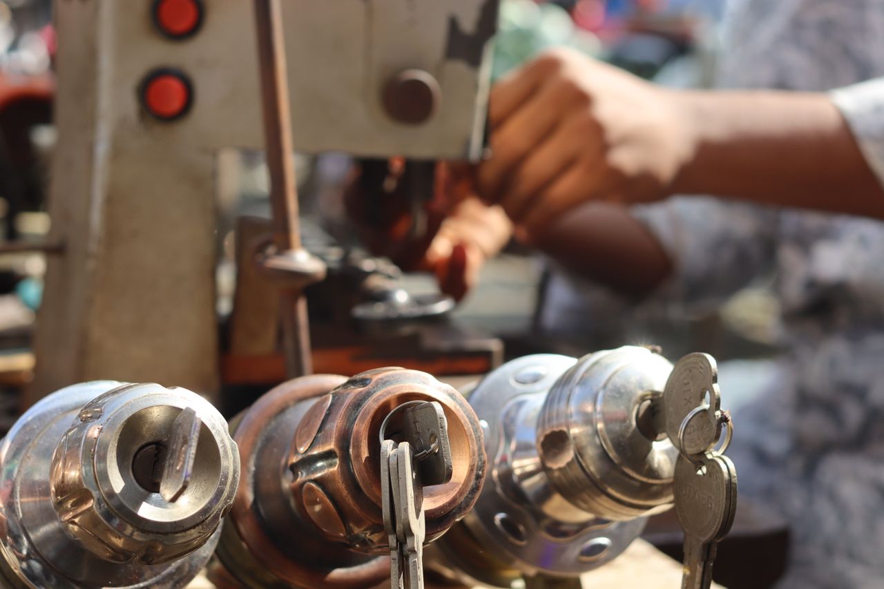 Locksmith hands working with a key cutting machine outdoors at a service van