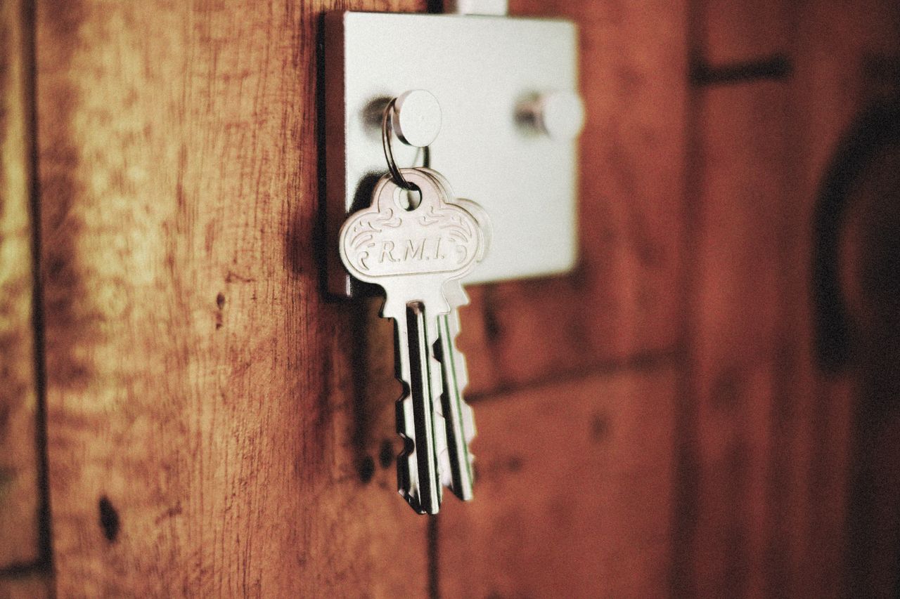 Keys hanging from a residential door lock in warm lighting