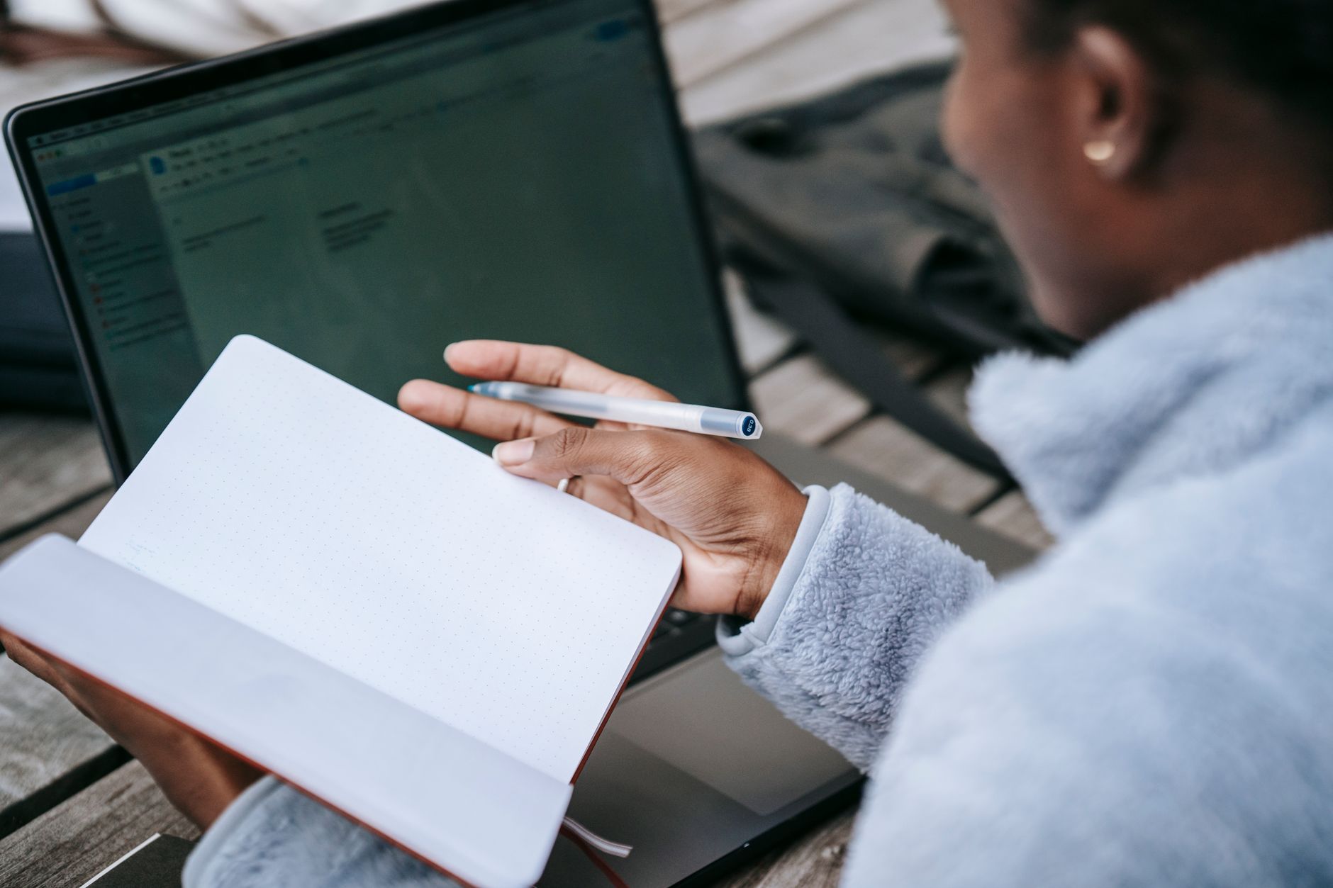 A woman taking notes from a laptop, researching personal injury claims and lawyers before making a decision