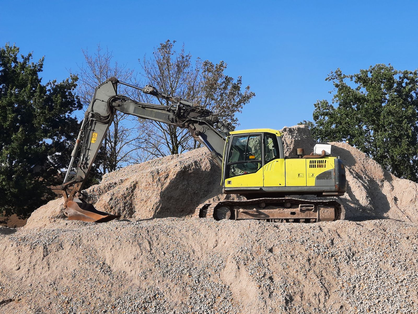 Excavator digging a foundation — the construction phase pool buyers research months before requesting estimates