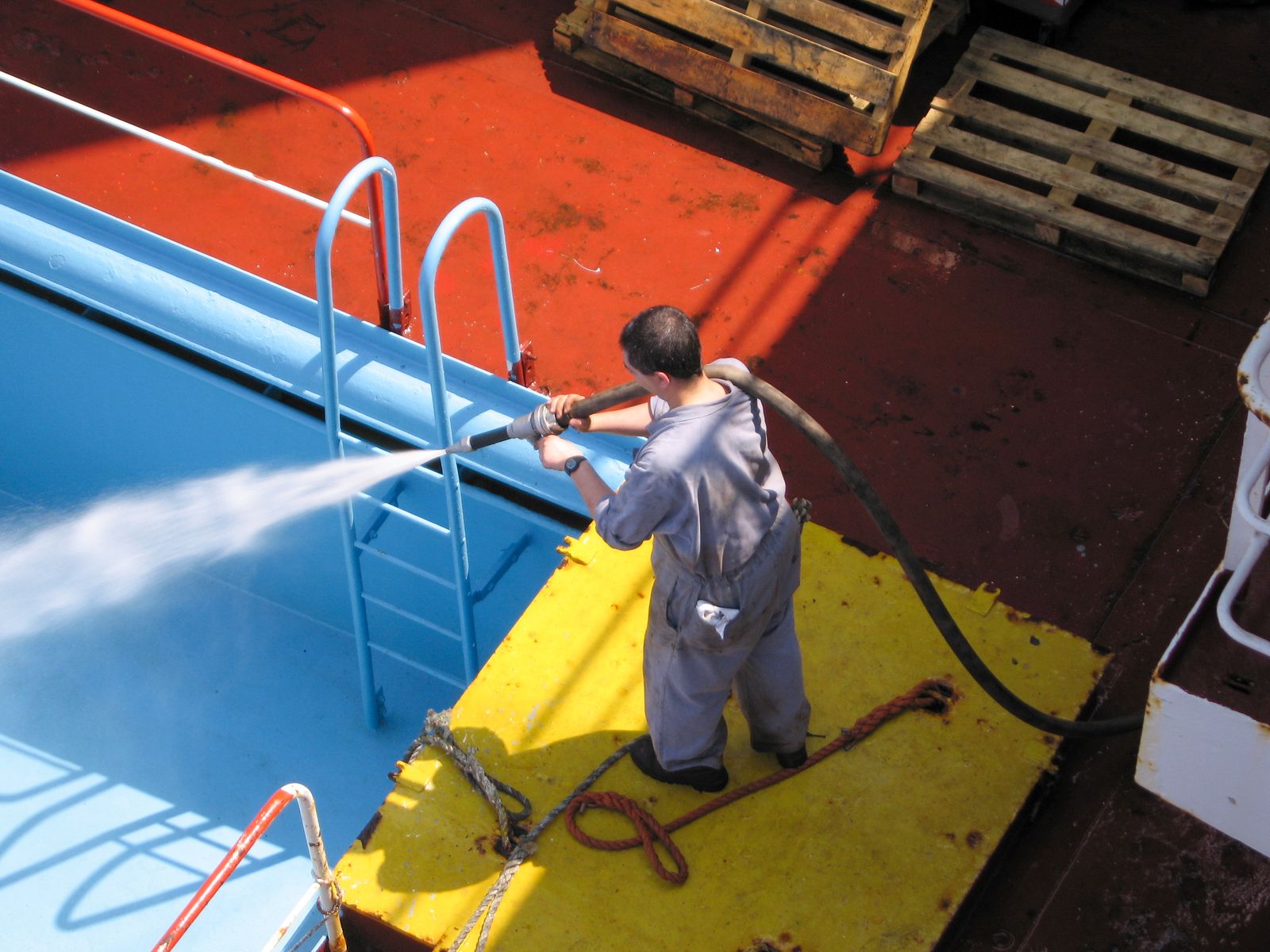 Worker spraying a surface clean with a high-pressure washer wand
