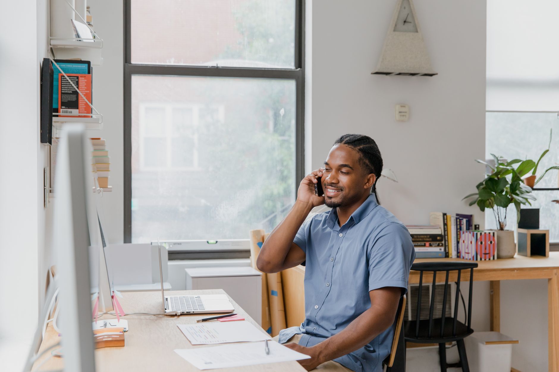 Small business owner on the phone reviewing marketing strategy at desk