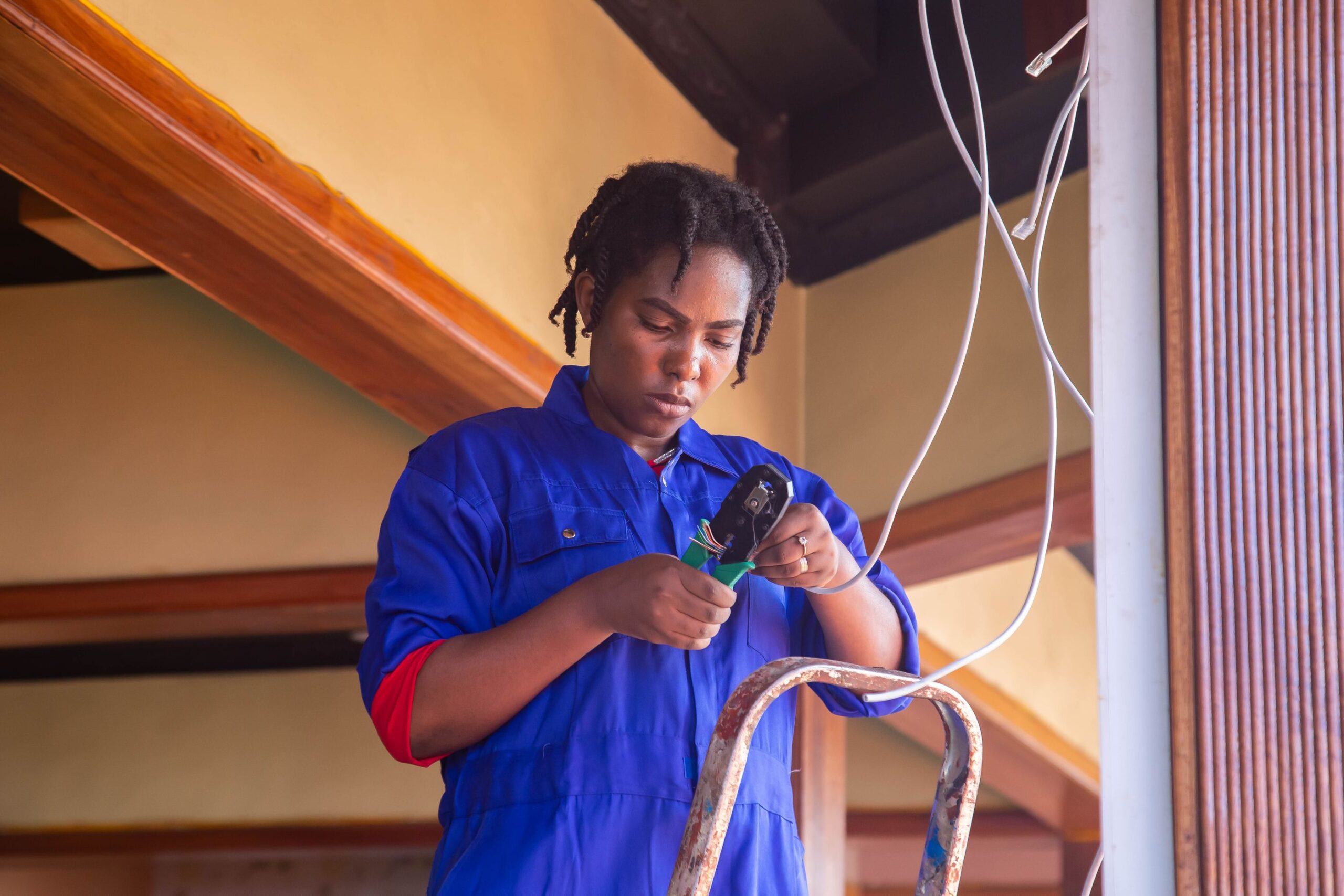 Residential electrician inspecting overhead electrical wiring during a home installation