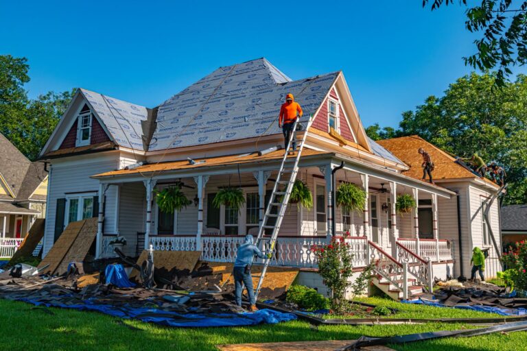 Roofing crew replacing the shingles on a residential home on a clear day