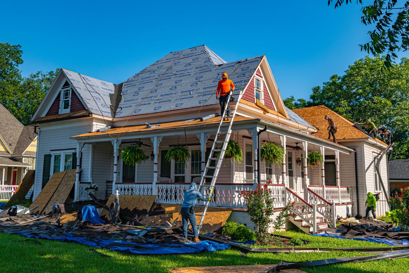 Roofing crew replacing the shingles on a residential home on a clear day