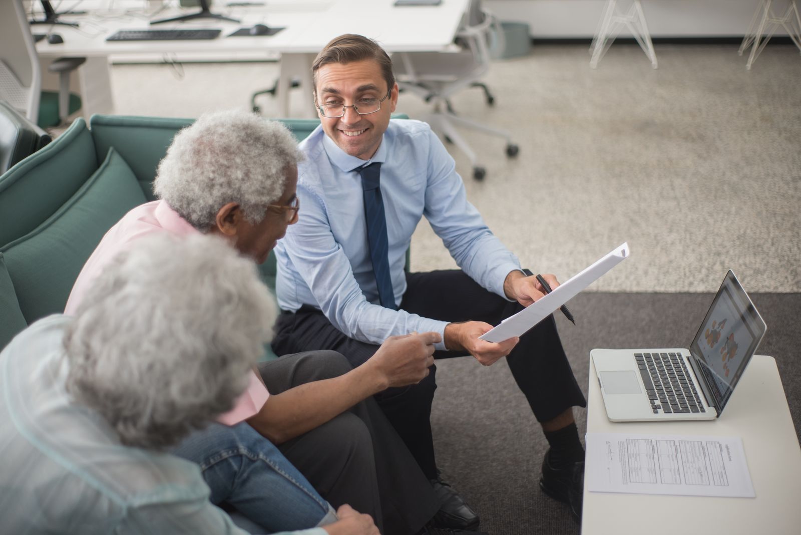 Financial advisor reviewing retirement plans with senior couple in office