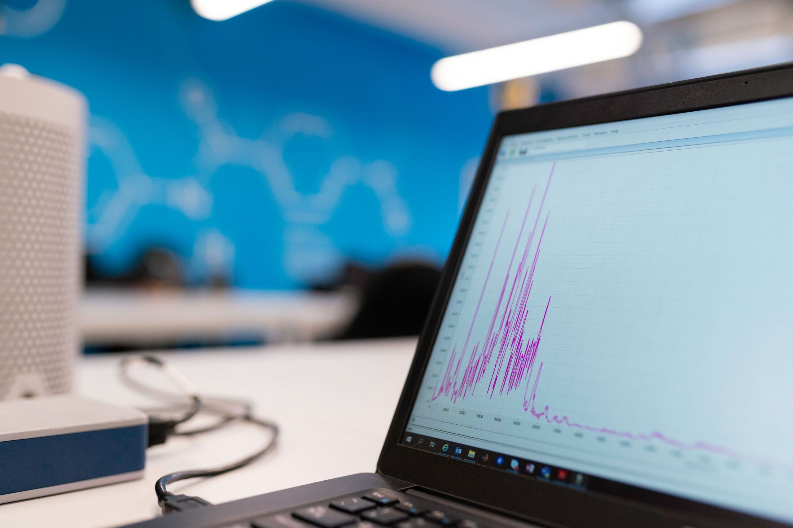 A laptop screen showing a rising traffic analytics graph in a modern office