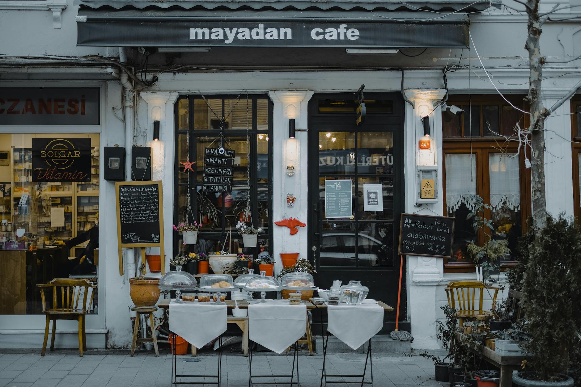 A local small business cafe storefront with menu boards and outdoor seating