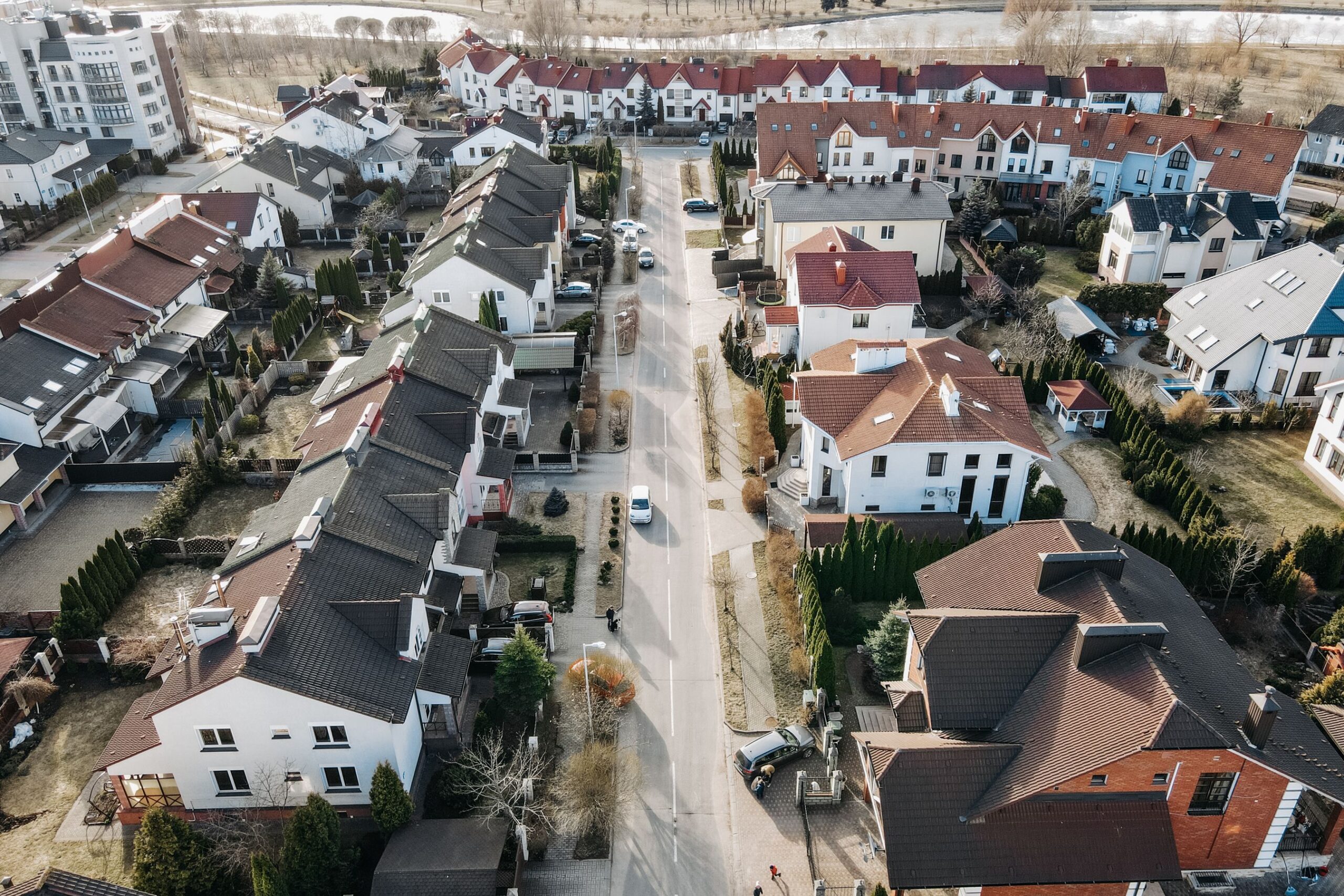 Aerial view of a suburban neighborhood with houses, streets and parked cars
