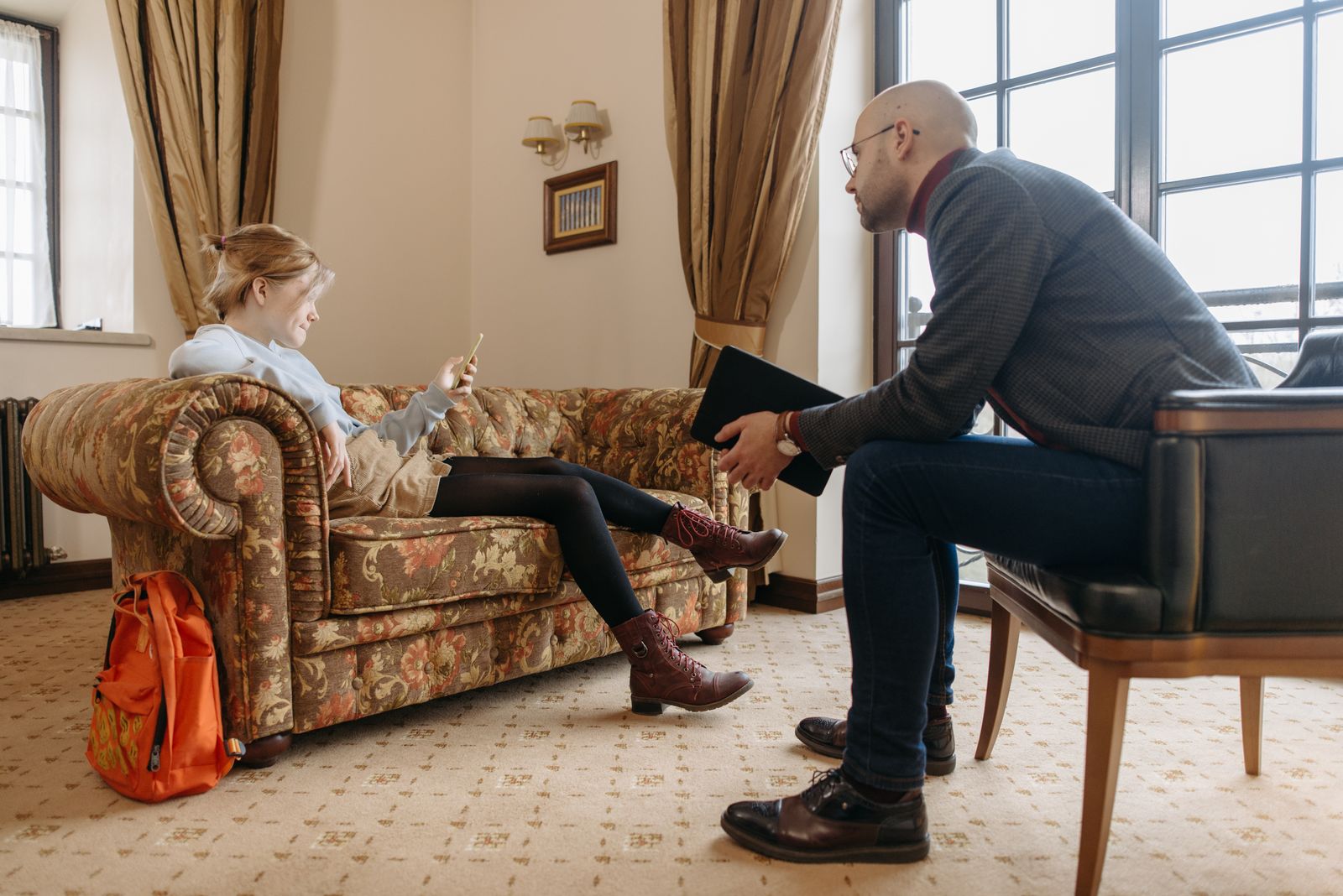 A counselor talking with a young client during a therapy session