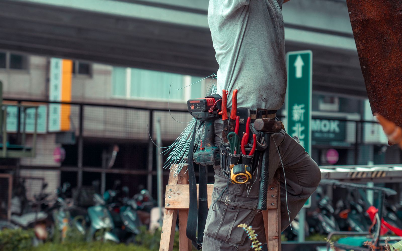 Service pro with a tool belt on a ladder — the kind of independent local business owner who benefits most from owning their lead pipeline
