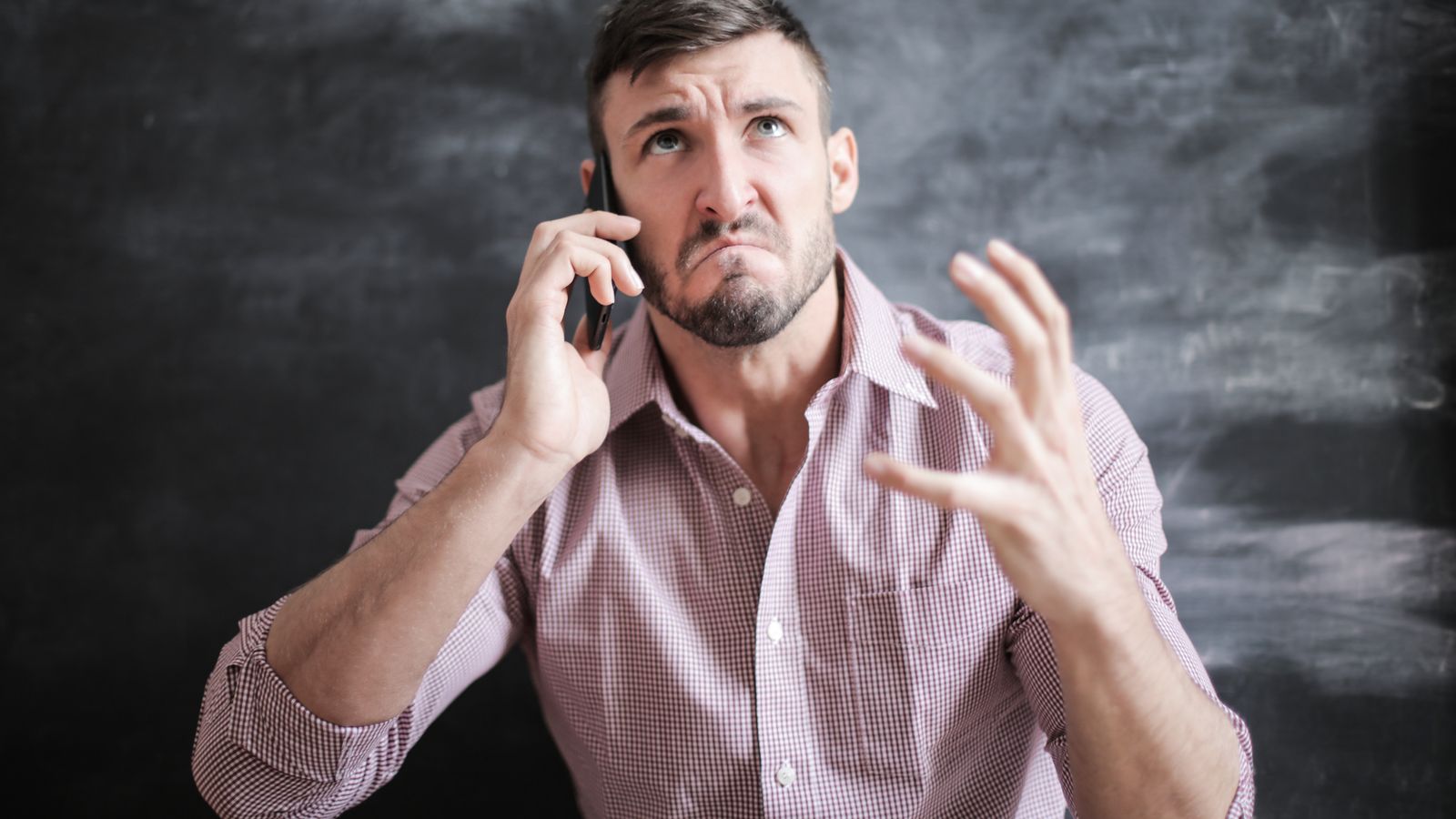 Stressed homeowner on the phone trying to find an emergency water damage restoration service
