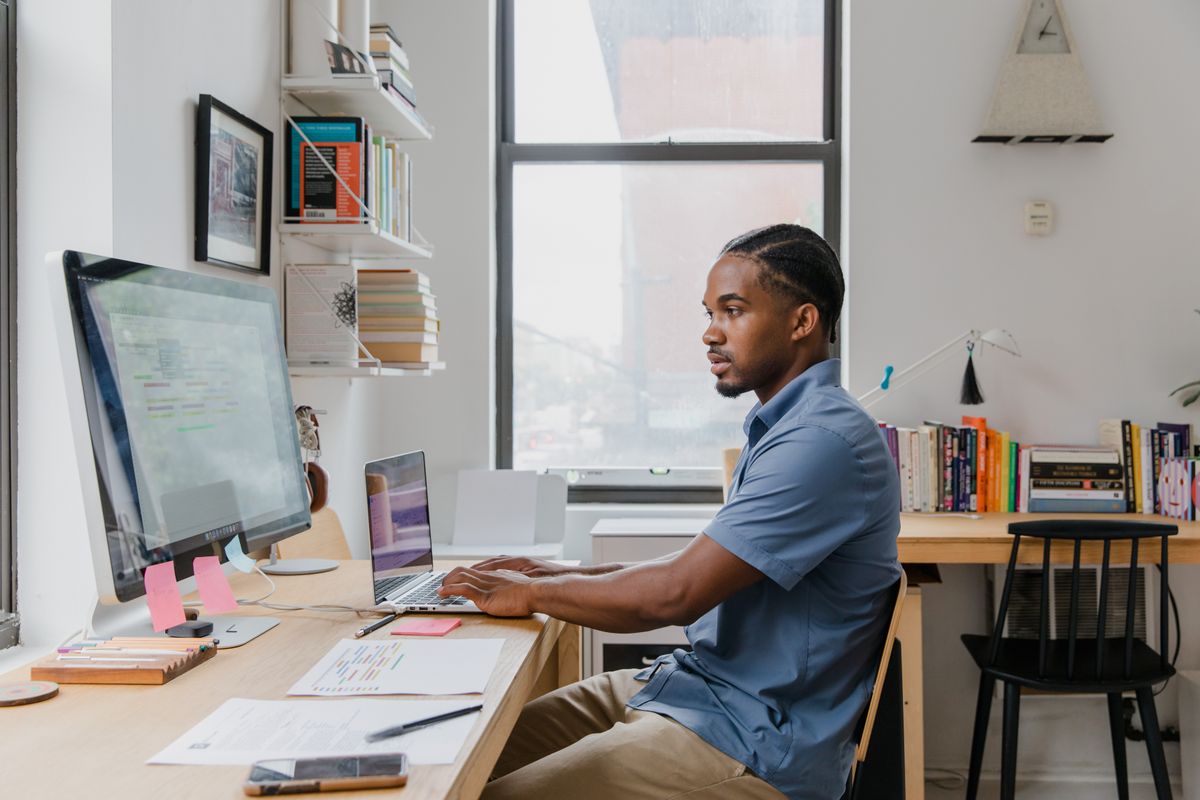 Small business owner reviewing website analytics on dual-monitor desk setup