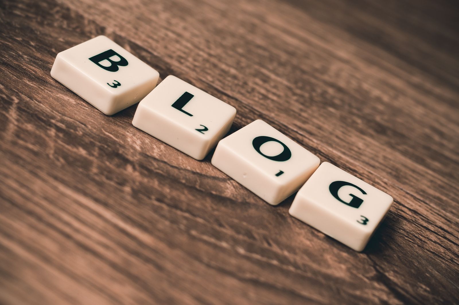 Scrabble tiles spelling the word BLOG on a wooden surface
