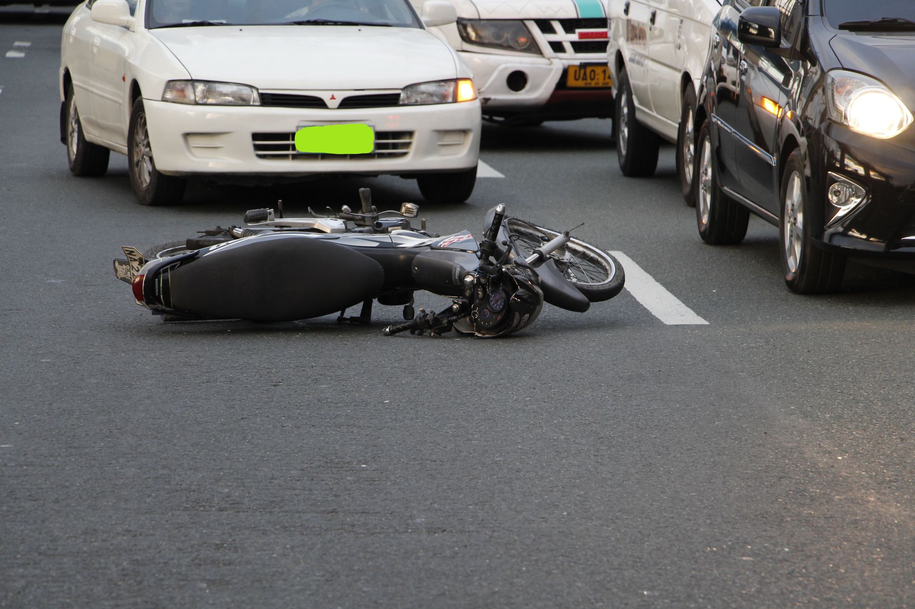 Motorcycle down on the road after a collision with cars in traffic, the kind of scene behind an injury claim