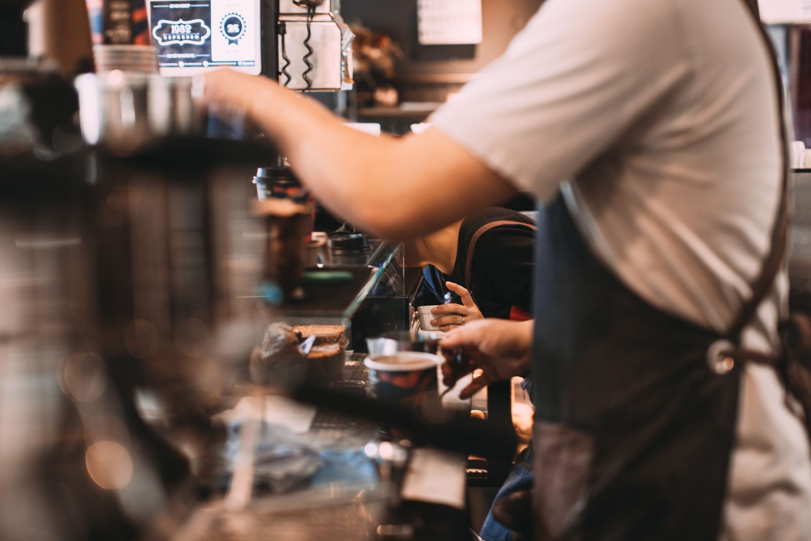 Barista serving customers in a busy local café that relies on local search traffic