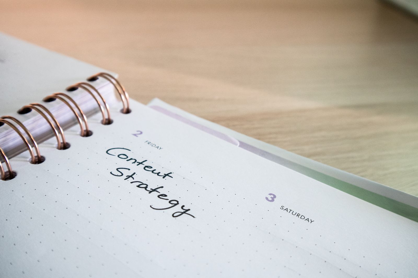 Content Strategy handwritten in a weekly planner notebook on a desk