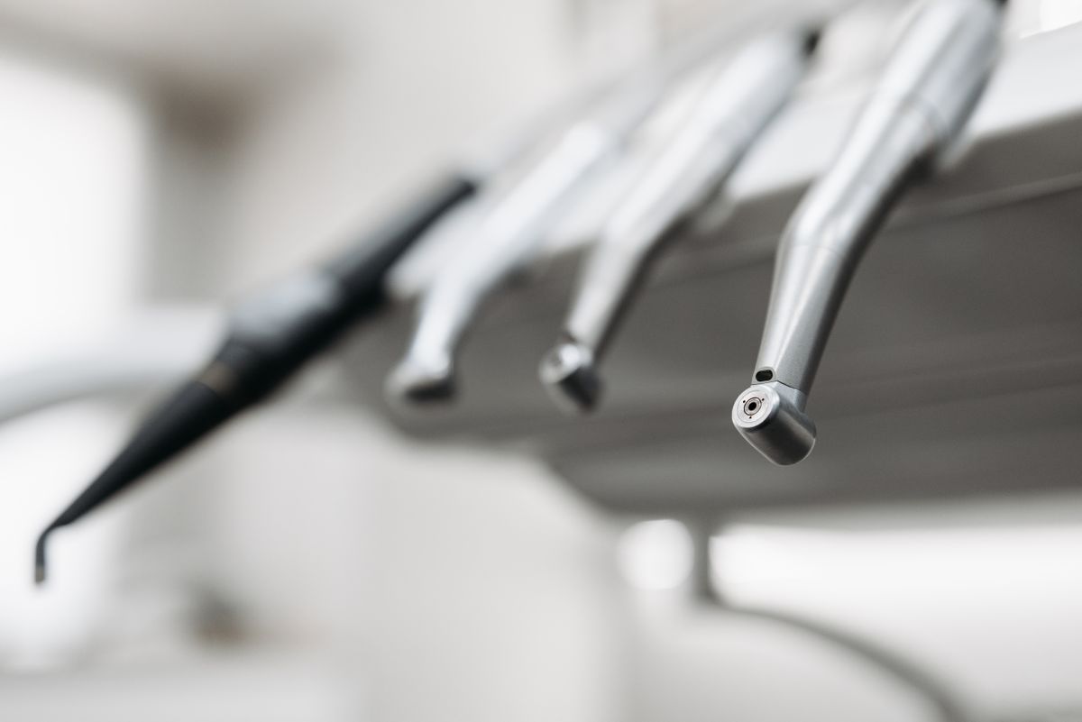 Close-up of dental handpiece instruments and tools mounted at a dental workstation