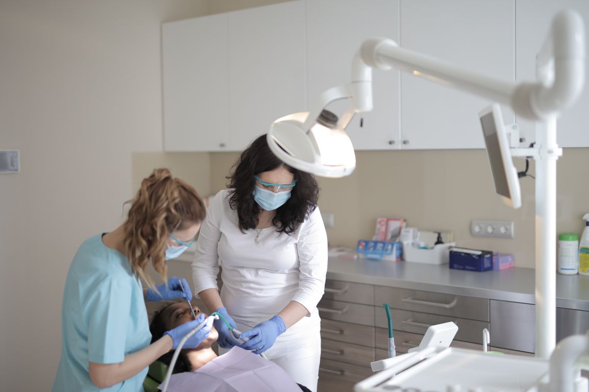 Dental team performing a treatment procedure on a patient in a fully equipped dental office
