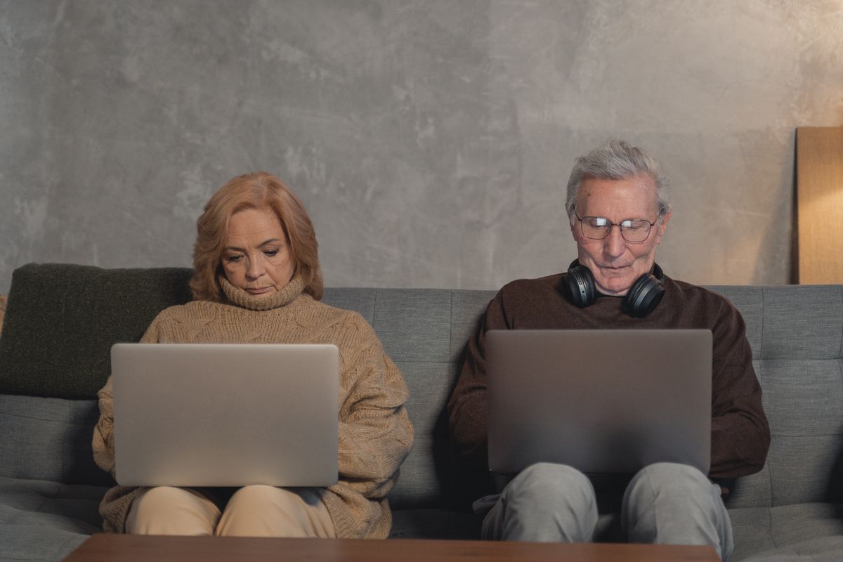Elderly couple using laptops to research home health care options online