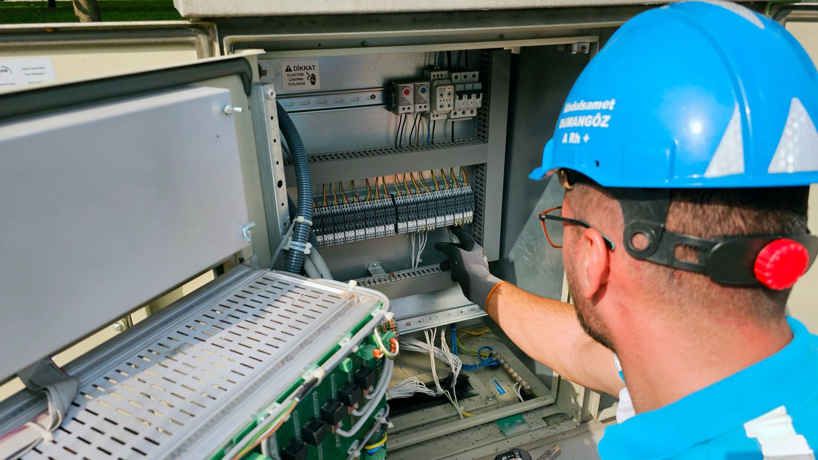 Electrician working on an outdoor fuse box during a service call
